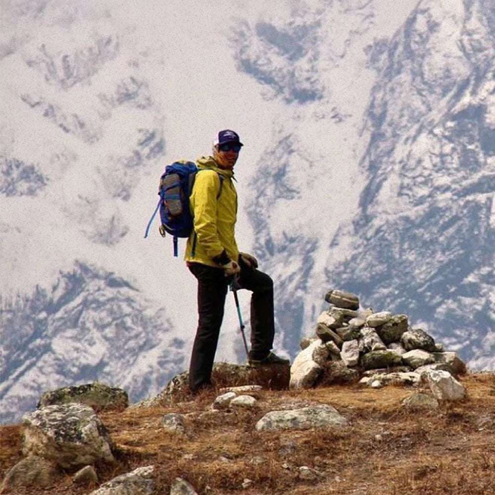 Man standing with snow-covered mountain in the background.