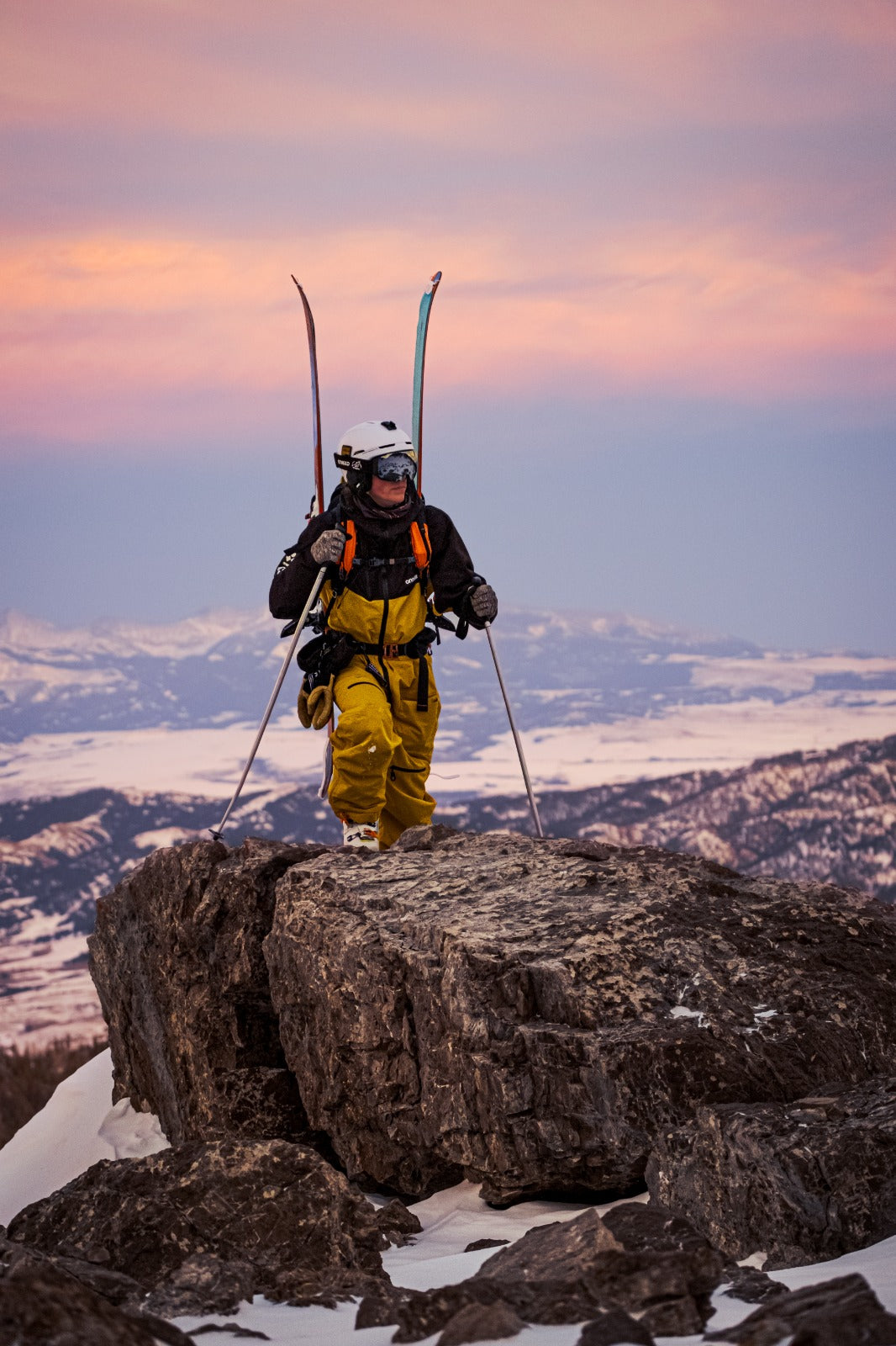 Man standing with snow-covered mountain in the background.